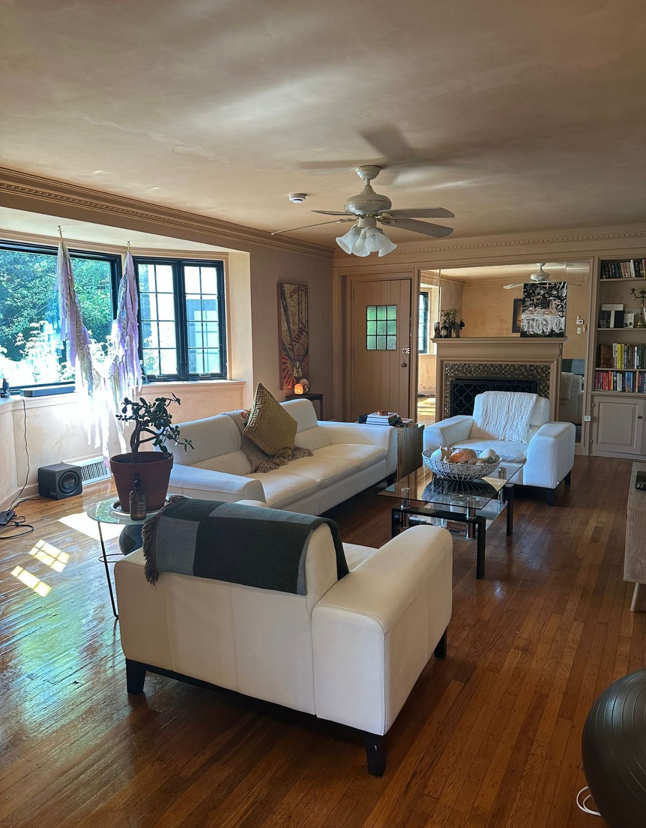 Spotless living room with white sofas and hardwood floors