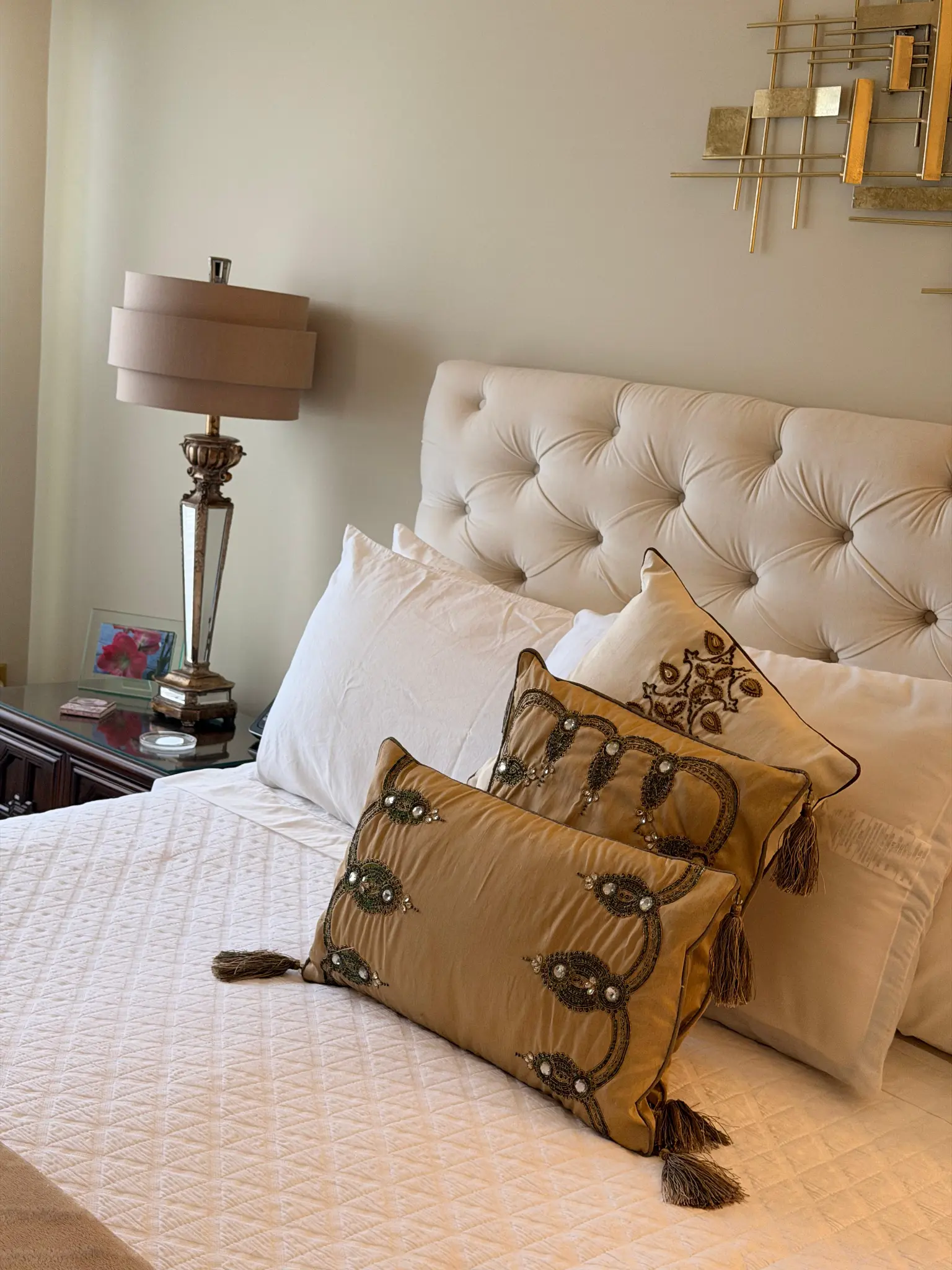 Elegant bedroom with tufted headboard and gold decor